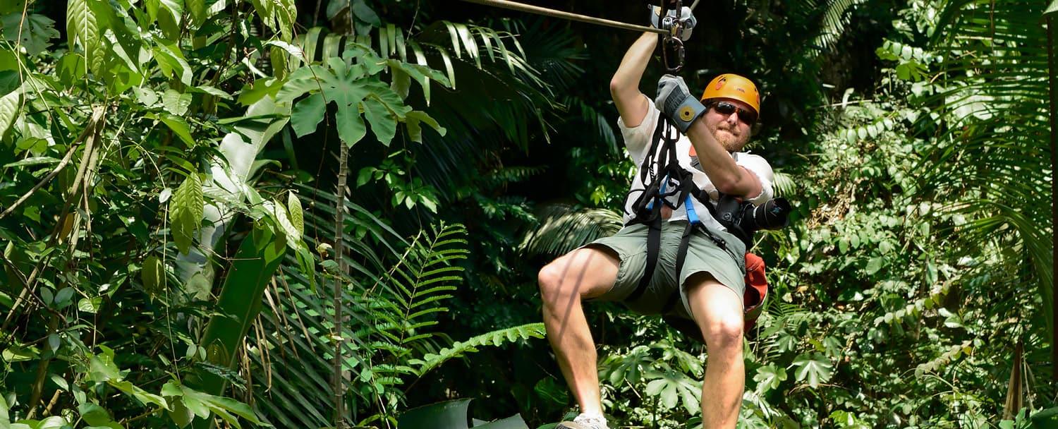 belize zipline with man in helmet and harness