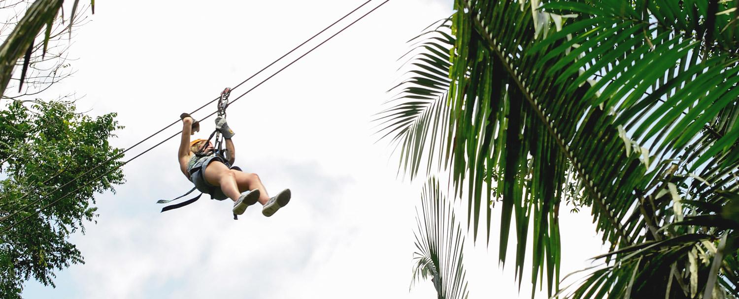 woman ziplining in belize through the jungle canopy